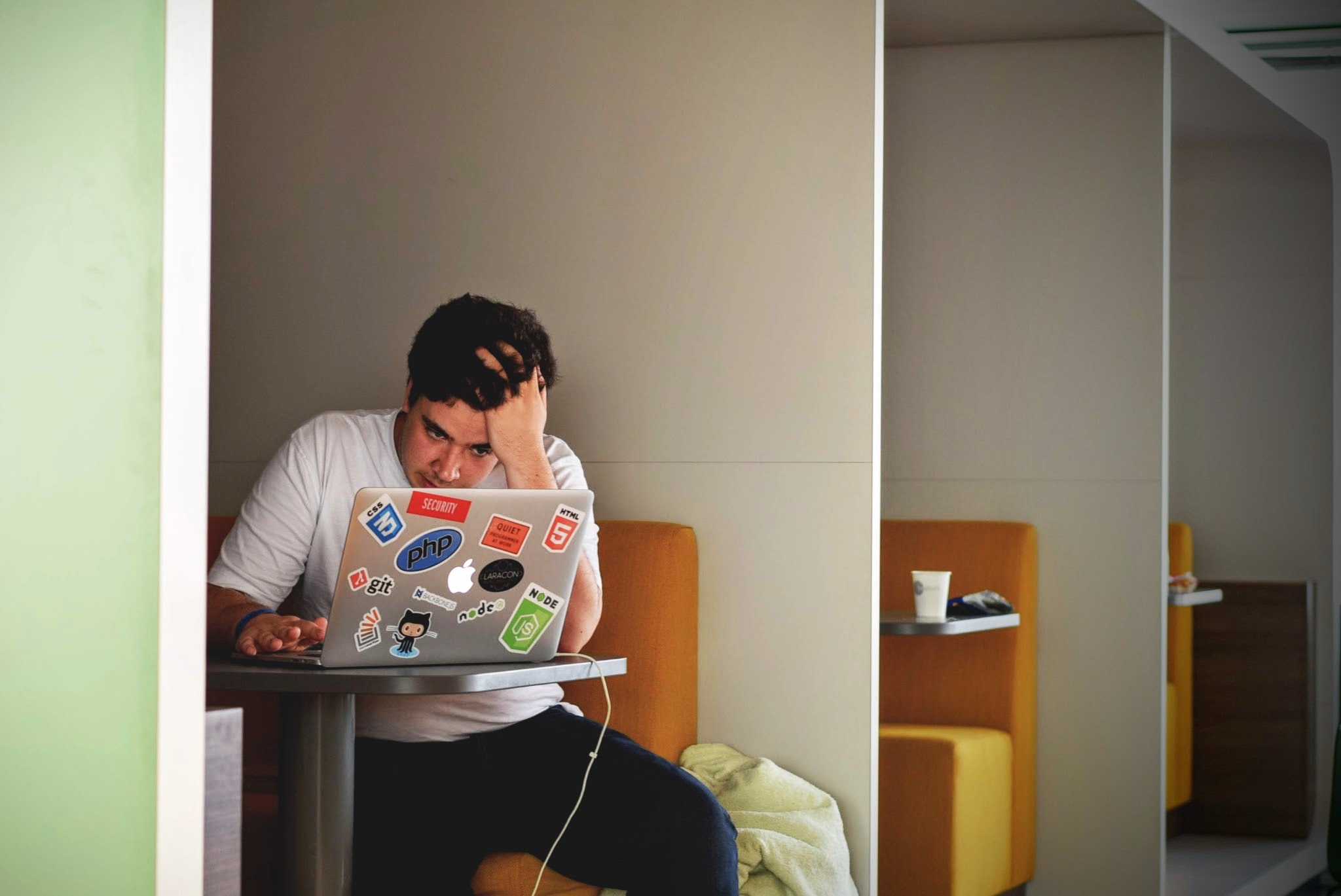 A picture of a student staring at his laptop stressed and confused.